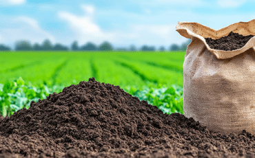 Fresh bag of nutrient-rich soil displayed on a farm background, ready for planting, gardening, and agricultural use.