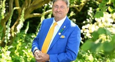 Beautiful cottage garden designed by Alan Titchmarsh featuring colorful flowering plants, lush greenery, and seasonal blooms.