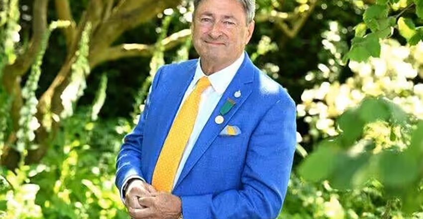 Beautiful cottage garden designed by Alan Titchmarsh featuring colorful flowering plants, lush greenery, and seasonal blooms.