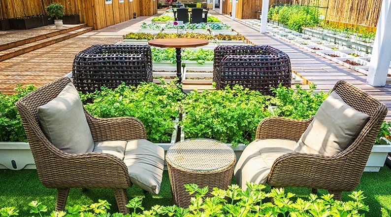 Covered lifestyle garden featuring a seamless indoor-outdoor living space with comfortable seating, lush greenery, and stylish landscaping.